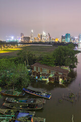 The modest dwellings on the opposite bank of the river stand in stark contrast to the contemporary flats of Ho Chi Minh City.