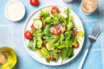 Green vegetable salad with fresh leaves on white plate. Healthy food, diet menu. Top view with space for text.