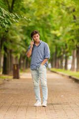 Portrait of man standing outside and talking on his phone