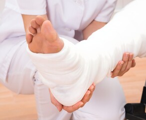 Obraz premium Female Doctor Holding Patient's Leg