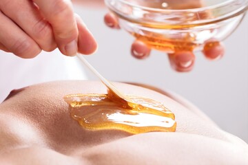 Therapist Applying Wax On Man's Body