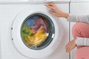 Woman Looking At Clothes Rotating Inside The Washing Machine