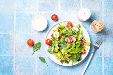 Green vegetable salad with fresh leaves on white plate. Healthy food, diet menu. Top view with space for text.