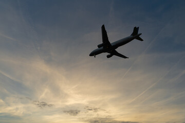 silhouette of an airplane against the cloudy evening sky
