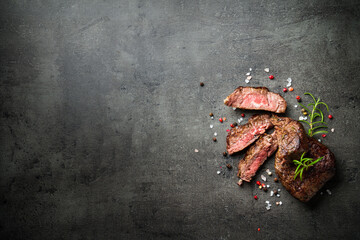 Meat steak on black backgound. Cutting Beef medallions with spices and herbs. Close up.