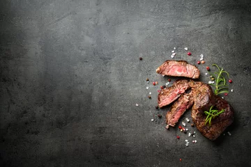 Foto op Aluminium Meat steak on black backgound. Cutting Beef medallions with spices and herbs. Close up. © nadianb