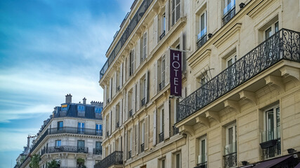 Paris, typical facade, beautiful building in the center with an hotel sign
