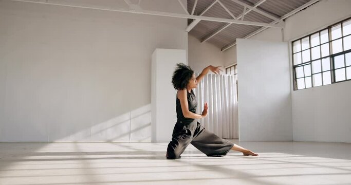 Dancing, fitness and performance of a woman in a creative art studio with energy and passion. African contemporary dancer practice for theater, sports and freedom with balance, exercise and talent