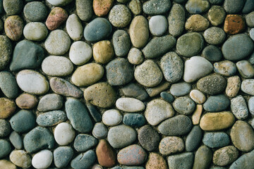 a wall of round stones, smooth neat stones from the shore, boulders.