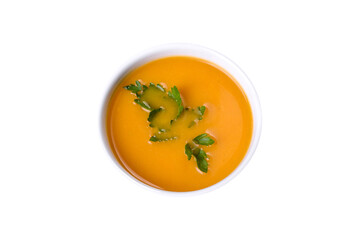 Delicious fresh pumpkin puree soup decorated with parsley in a white plate