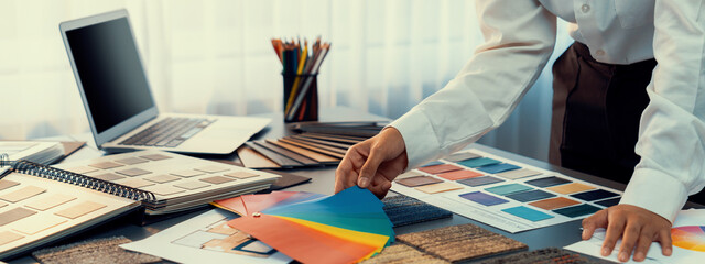 Interior architect designer at workstation table choosing various color samples art tool design...