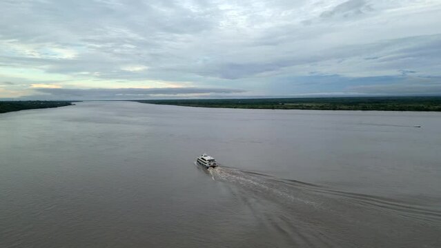 Aerial tracking shot of a ferry driving along the Amazon River near Iquitos, Peru