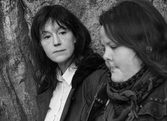 Fototapeta premium Portrait of two friends standing against mountain wall