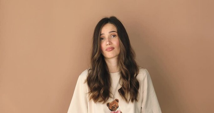 Perplexed dissatisfied woman looks frustrated at camera says I don't agree has puzzled face expression dressed casually isolated over beige background. Girl shake her head. No, deny.