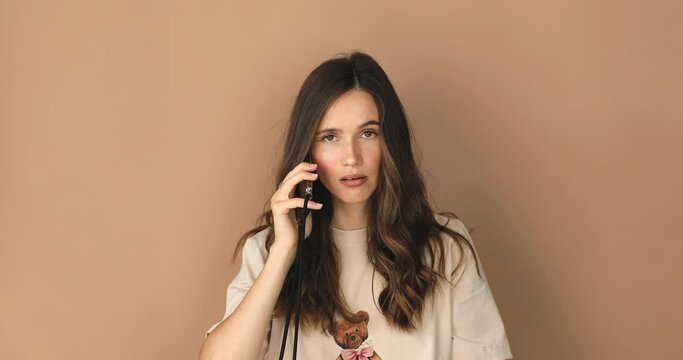 Brunette woman talk by mobile phone, show gesture blah blah blah. Doesn't want talk on cellphone show gesture bla by hand. Bored angry girl.