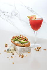 red fig and bruschetta cocktail with figs, gorgonzola and walnuts on a white marble table