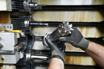 A worker inspects and changes a high-speed cutter on a CNC milling machine.