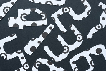 large abstract looking numbers (123) machine-cut from black and white paper with spots, rings, or dots on blank paper