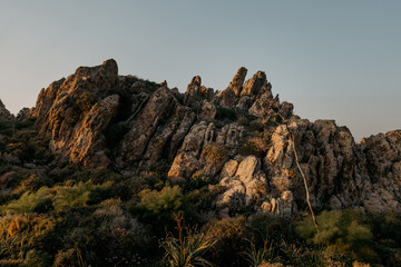 stone jagged mountains at sunset with thickets of wild fennel