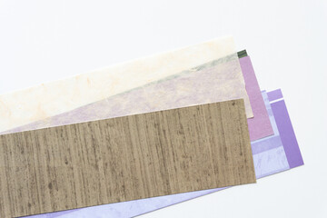 paper background with pile of scrapbooking paper samples on blank paper