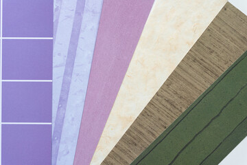 paper background featuring an array of scrapbooking paper samples from purple to green