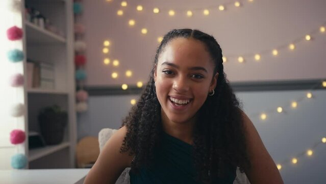 Portrait of laughing teenage girl at home in bedroom sitting at mirror getting ready for prom or night  - shot in slow motion