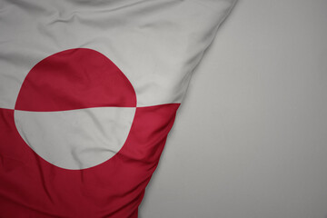 big waving national colorful flag of greenland on the gray background. © luzitanija