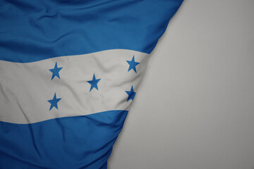 big waving national colorful flag of honduras on the gray background.