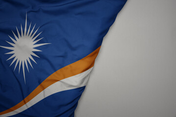 big waving national colorful flag of Marshall Islands on the gray background.