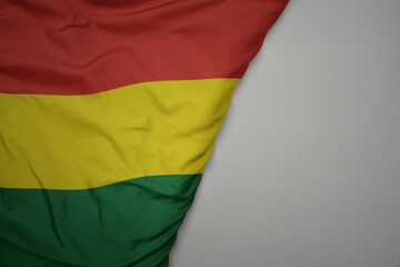 big waving national colorful flag of bolivia on the gray background.