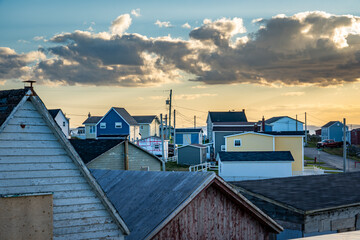 Look-out view of rooftops and East Coast homes overlooking a distant Atlantic sunset in Bonavista Newfoundland Canada.