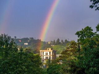 Rainbow in the mountains. Rainbow over a house in the mountains. Beautiful and cozy place.