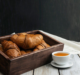Freshly baked croissants and coffee. Side view. Copyspace. Cup of coffee with chocolate croissants. Fresh homemade cakes