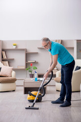 Old male contractor cleaning the house