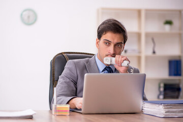 Fototapeta premium Young male employee working in the office