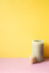 Aromatic candle on pink table. yellow background. copy space