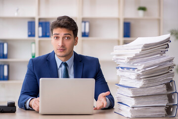 Young male employee and too much work in the office