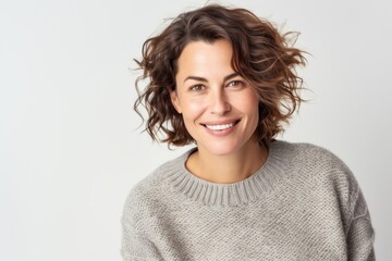 Portrait photography of a French woman in her 40s wearing a cozy sweater against a white background