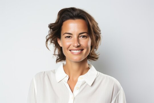Portrait photography of a French woman in her 30s wearing a simple tunic against a white background