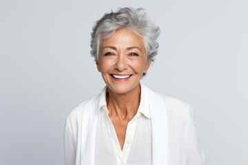 Fototapeta premium Portrait photography of a Colombian woman in her 60s wearing a classic blazer against a white background