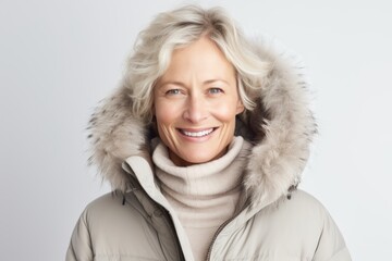 Lifestyle portrait photography of a Swedish woman in her 50s wearing a warm parka against a white background