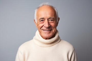Obraz premium Medium shot portrait photography of a French man in his 80s wearing a cozy sweater against a minimalist or empty room background
