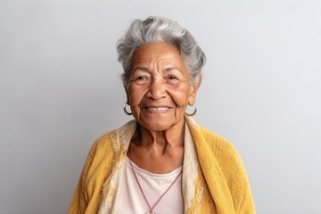 Medium shot portrait photography of a 100-year-old elderly Colombian woman against a minimalist or empty room background