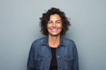 Close-up portrait photography of a Italian woman in her 40s wearing a denim jacket against a minimalist or empty room background - obrazy, fototapety, plakaty