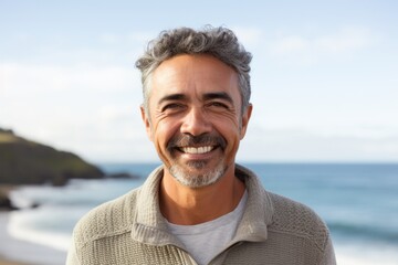Medium shot portrait photography of a Colombian man in his 50s against a beach background