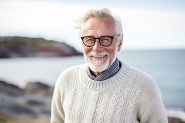 Medium shot portrait photography of a Swedish man in his 80s against a beach background
