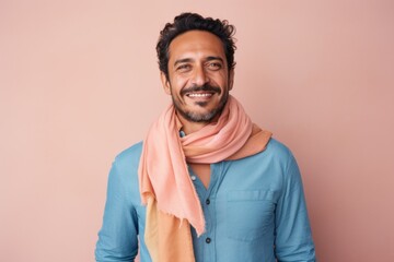 Lifestyle portrait photography of a Peruvian man in his 30s wearing a foulard against a pastel or soft colors background