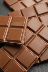 Delicious milk chocolate on black table, closeup
