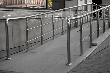 Ramp with metal handrails near building outdoors