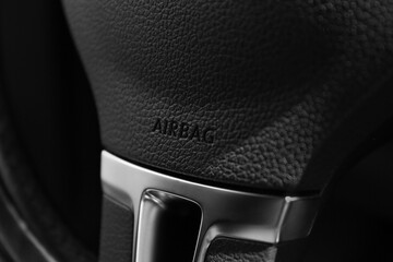 Safety airbag sign on steering wheel in car, closeup